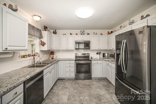 kitchen featuring light stone countertops, stainless steel appliances, white cabinets, and sink