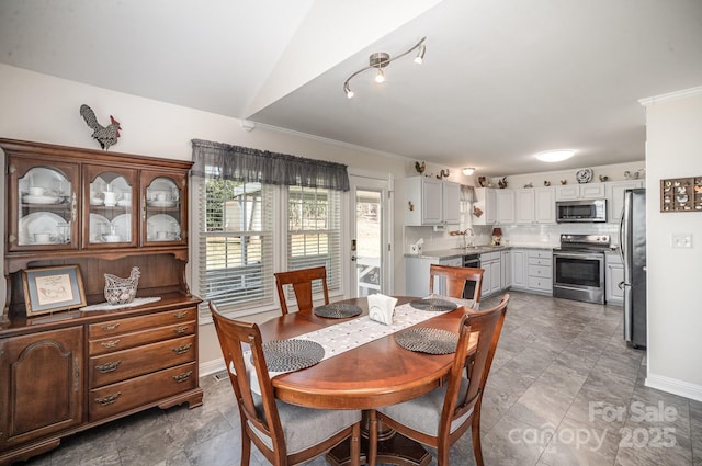 dining area with sink and vaulted ceiling