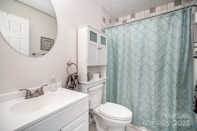 bathroom featuring toilet, a shower with shower curtain, and vanity