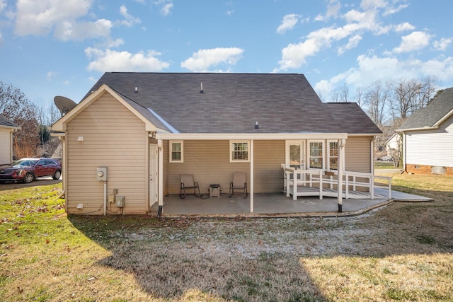 back of property with a patio area and a lawn