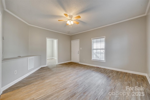 spare room featuring a textured ceiling, ceiling fan, ornamental molding, and light hardwood / wood-style flooring