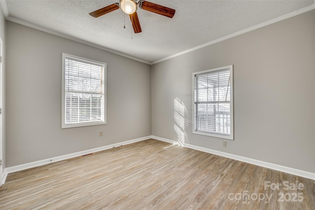 spare room featuring ceiling fan, a healthy amount of sunlight, light wood-type flooring, and a textured ceiling