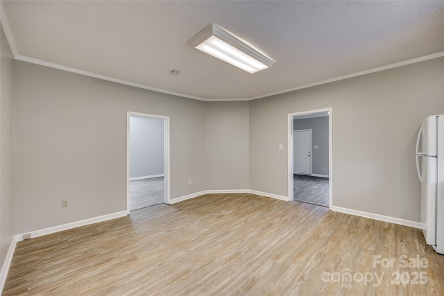 unfurnished room featuring light wood-type flooring and crown molding