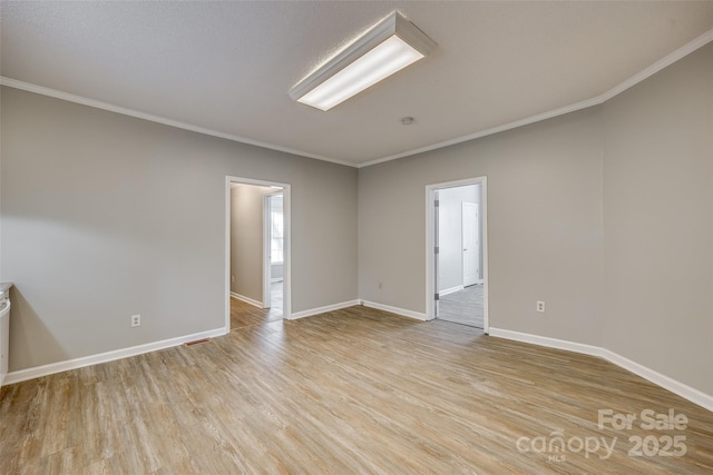 empty room featuring ornamental molding and light hardwood / wood-style flooring