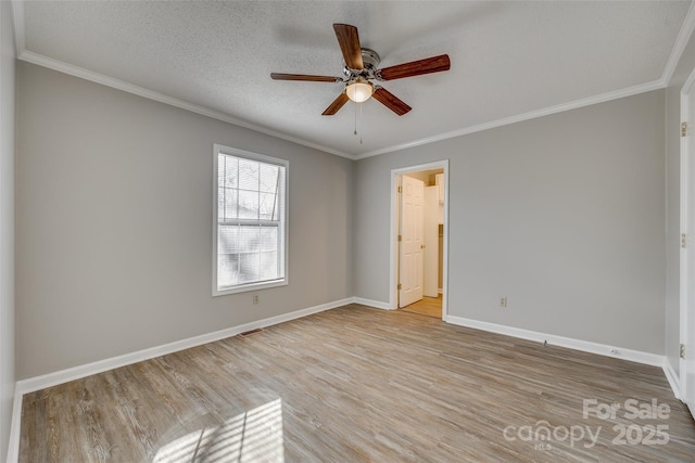 empty room with a textured ceiling, ornamental molding, and light hardwood / wood-style floors