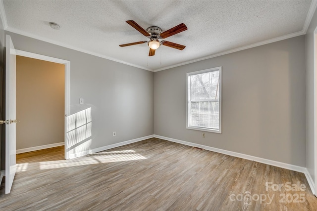 spare room with a textured ceiling, ceiling fan, crown molding, and light hardwood / wood-style floors