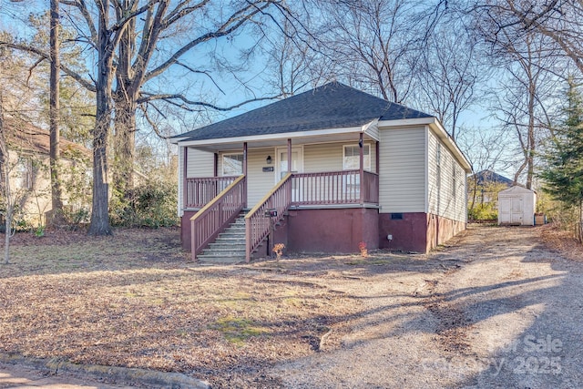 view of front of home with a porch and a storage unit