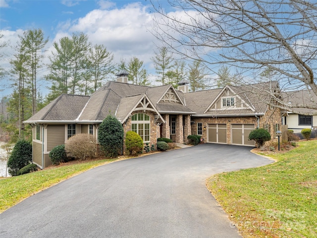 craftsman inspired home with a garage and a front lawn