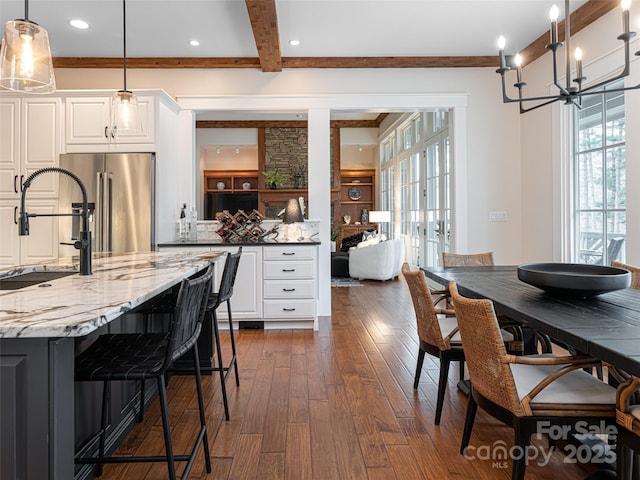 kitchen with white cabinets, pendant lighting, dark hardwood / wood-style flooring, high quality fridge, and sink