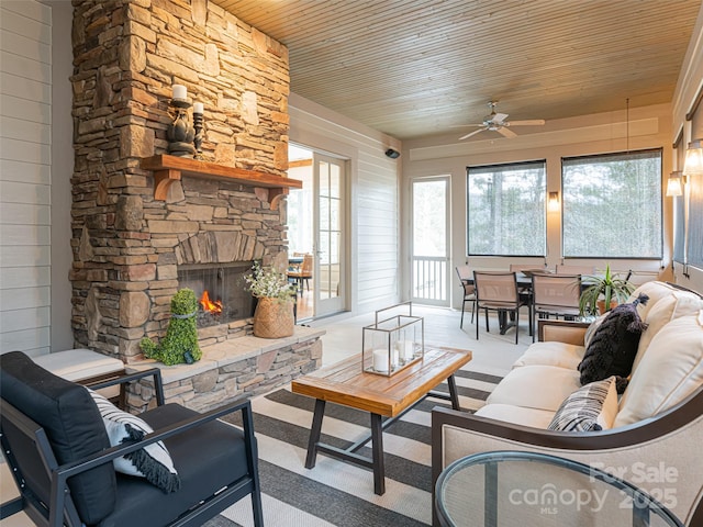 sunroom / solarium featuring ceiling fan, wooden ceiling, and a fireplace