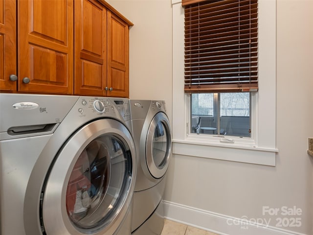 clothes washing area featuring cabinets, independent washer and dryer, and light tile patterned floors