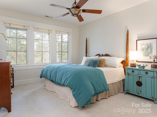 bedroom featuring multiple windows, light carpet, and ceiling fan