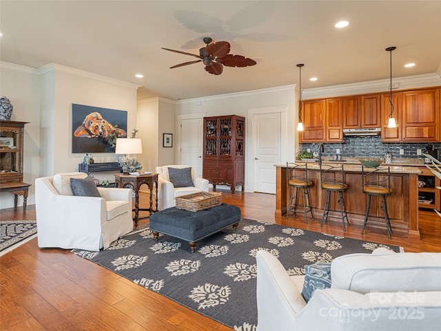 living room with ceiling fan, dark wood-type flooring, and crown molding