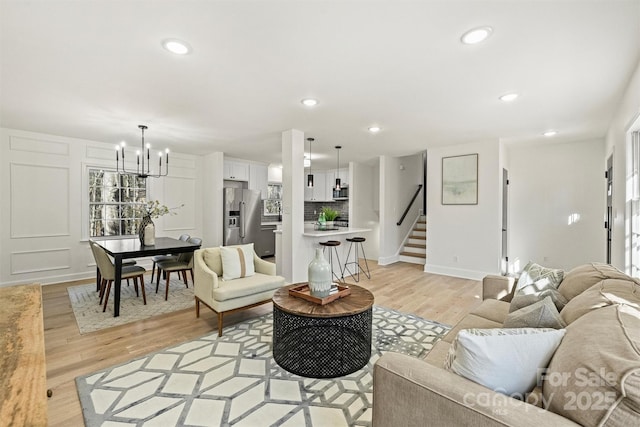 living room with a notable chandelier and light hardwood / wood-style flooring