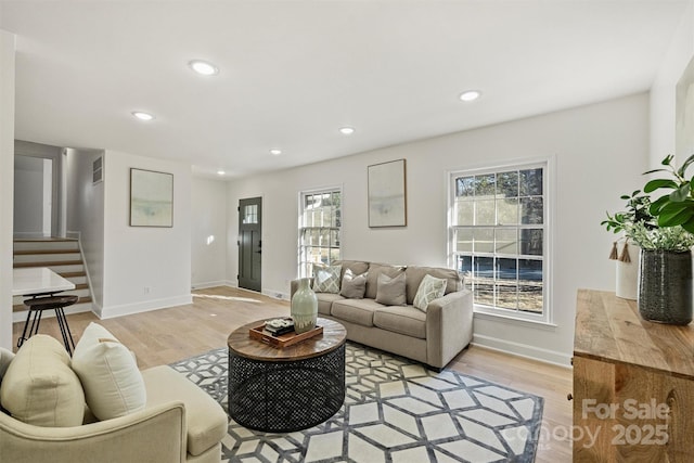 living room featuring a healthy amount of sunlight and light hardwood / wood-style floors