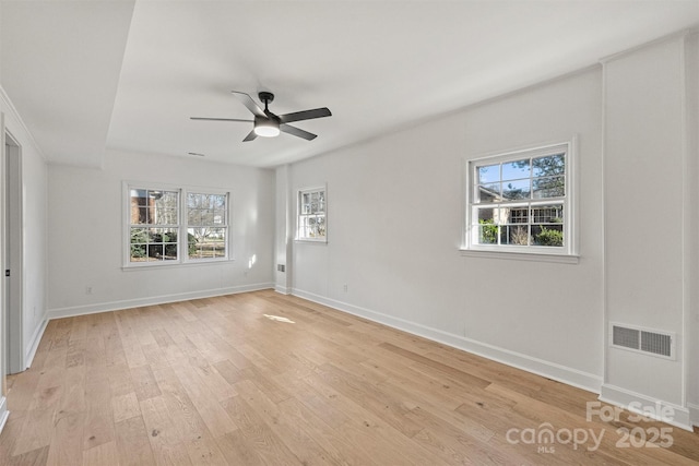 unfurnished room featuring a healthy amount of sunlight, ceiling fan, and light hardwood / wood-style flooring