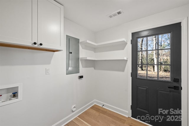 laundry room with electric dryer hookup, washer hookup, electric panel, cabinets, and light hardwood / wood-style floors