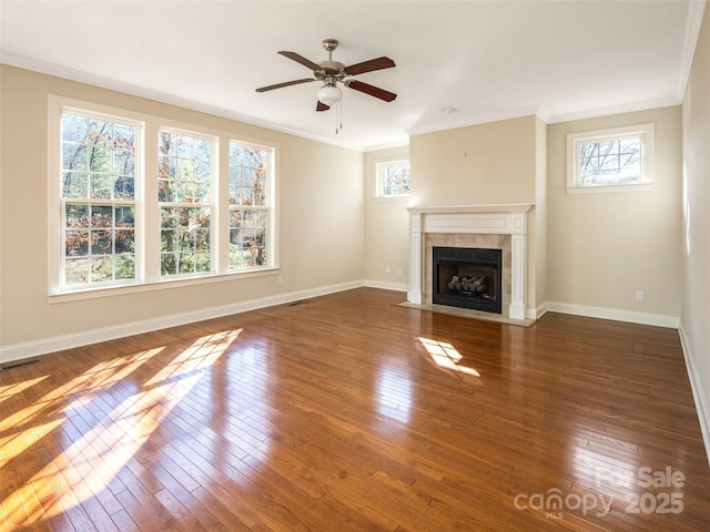 unfurnished living room with a fireplace, dark hardwood / wood-style floors, ceiling fan, and crown molding