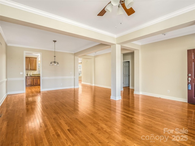 unfurnished living room with crown molding, ceiling fan, and light wood-type flooring