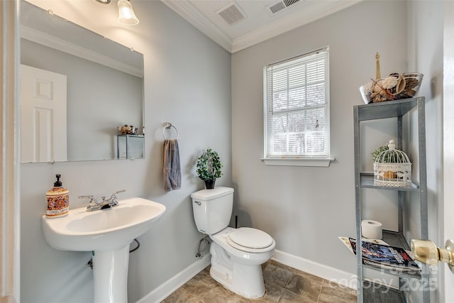 bathroom with toilet, ornamental molding, and sink