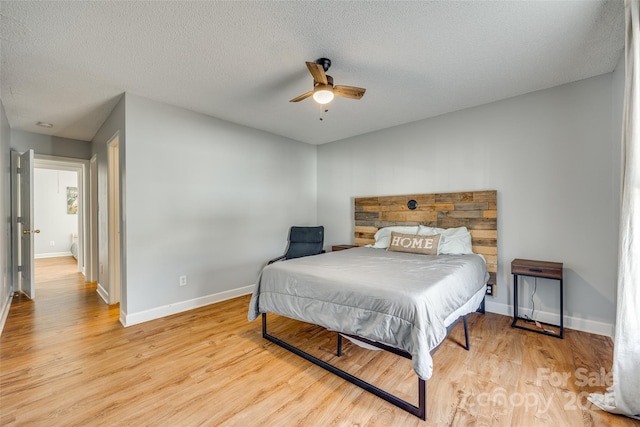 bedroom featuring a textured ceiling, ceiling fan, and light hardwood / wood-style floors