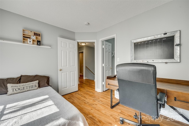 bedroom with a textured ceiling and hardwood / wood-style floors