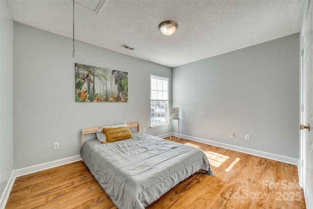 bedroom featuring a textured ceiling and light wood-type flooring