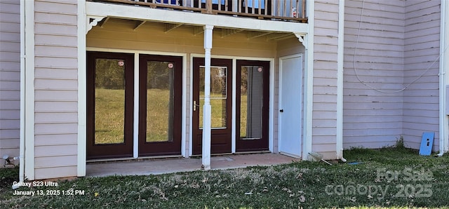 view of exterior entry with a balcony