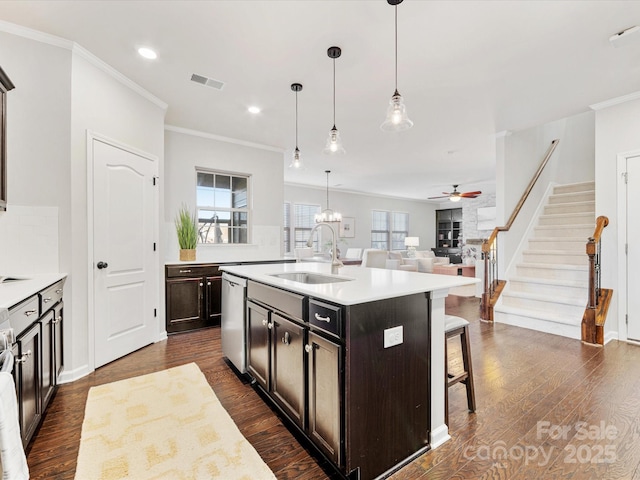 kitchen featuring sink, a center island with sink, a kitchen breakfast bar, and hanging light fixtures