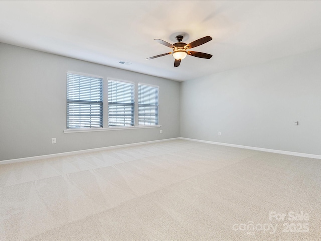 spare room with ceiling fan and light colored carpet