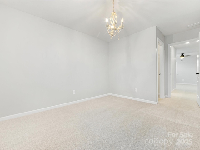 spare room with ceiling fan with notable chandelier and light carpet