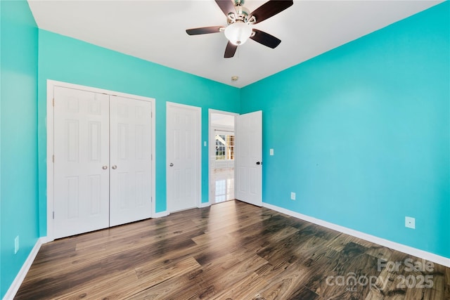 unfurnished bedroom featuring dark wood-type flooring and ceiling fan