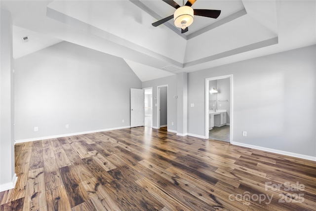 interior space featuring a raised ceiling, ceiling fan, and hardwood / wood-style flooring