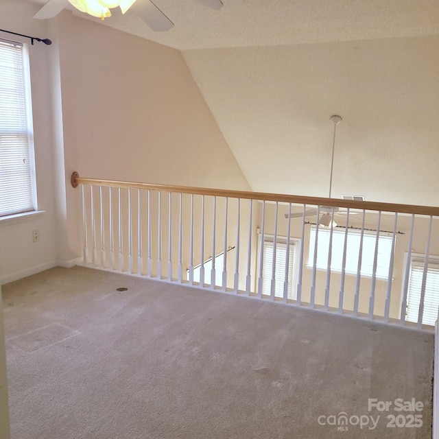 carpeted empty room with ceiling fan and vaulted ceiling