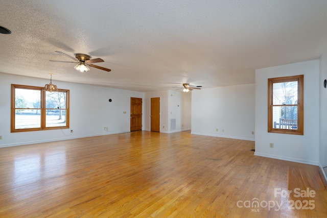 spare room featuring ceiling fan, a wealth of natural light, and light hardwood / wood-style flooring