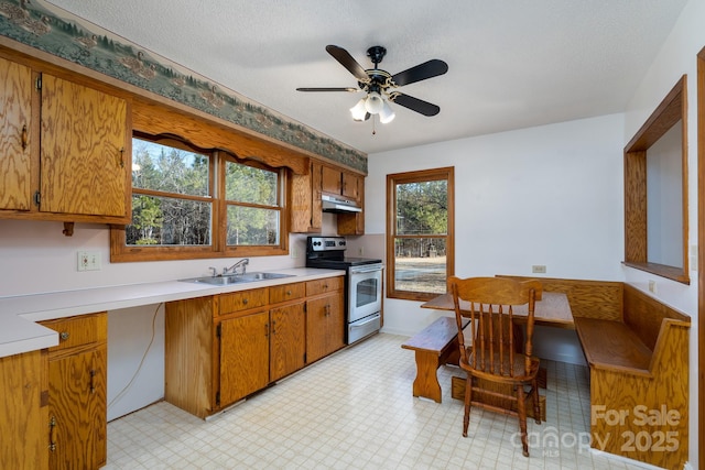 kitchen with stainless steel electric stove, sink, a textured ceiling, and ceiling fan