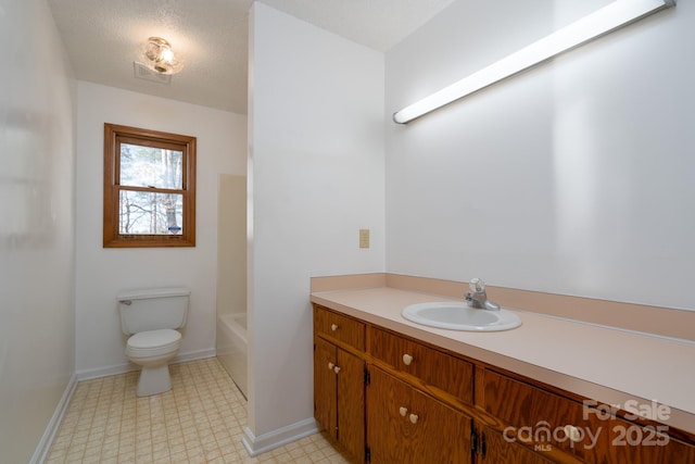 bathroom featuring toilet, a textured ceiling, and vanity