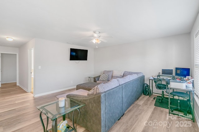 living area with light wood finished floors, baseboards, and a ceiling fan