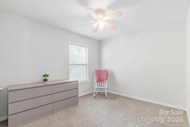 living area featuring light carpet, ceiling fan, and baseboards