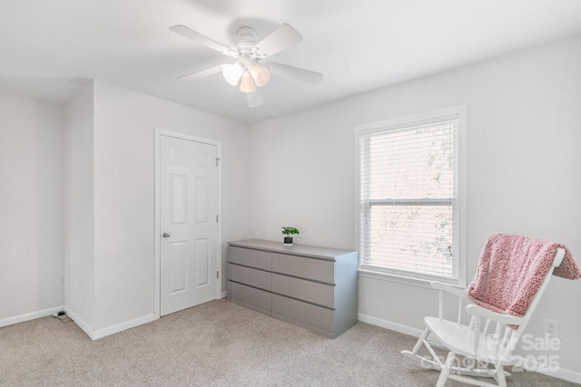 sitting room featuring light carpet, ceiling fan, plenty of natural light, and baseboards