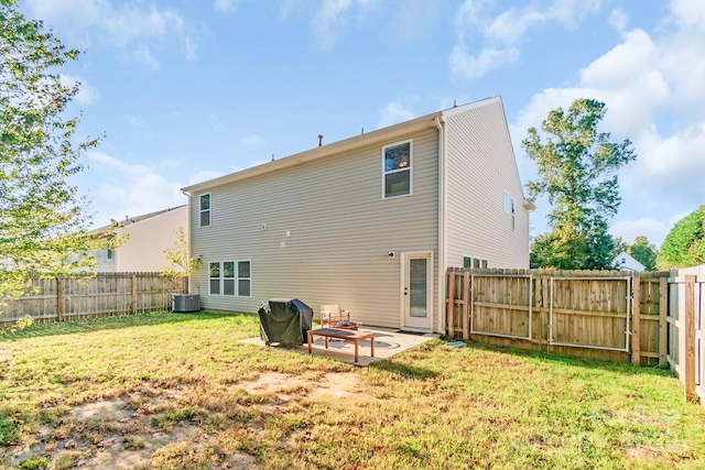 rear view of property with an outdoor fire pit, a lawn, and a fenced backyard