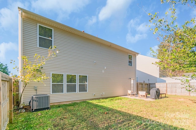 rear view of property featuring cooling unit, a patio area, a fenced backyard, and a yard