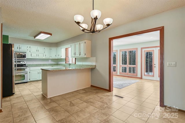 kitchen featuring sink, decorative light fixtures, appliances with stainless steel finishes, kitchen peninsula, and light stone countertops