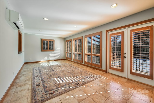 spare room with light tile patterned flooring, french doors, and an AC wall unit