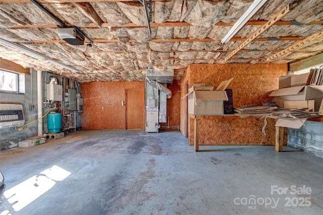 misc room featuring water heater, heating unit, concrete floors, and electric panel