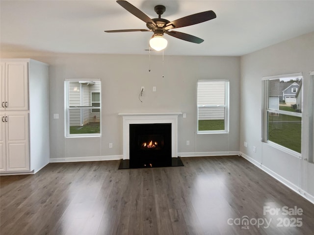 unfurnished living room with ceiling fan and dark hardwood / wood-style floors