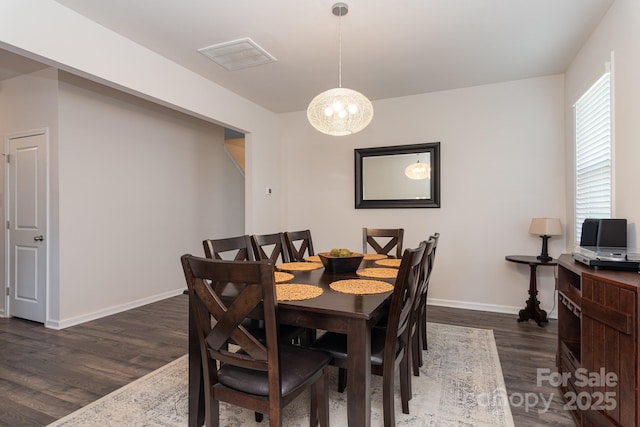 dining area featuring dark hardwood / wood-style floors and a chandelier