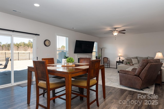 dining area with ceiling fan and dark wood-type flooring