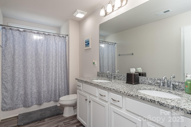 bathroom with wood-type flooring, toilet, and vanity