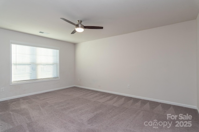 spare room with ceiling fan and light carpet